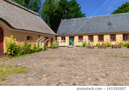 Historic Scandinavian farmhouse with cobblestone courtyard Historic Scandinavian farmhouse with cobblestone courtyard 141592607