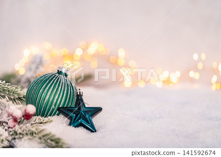 Green Christmas Ornament with Silver Ribbon on Snowy Surface 141592674