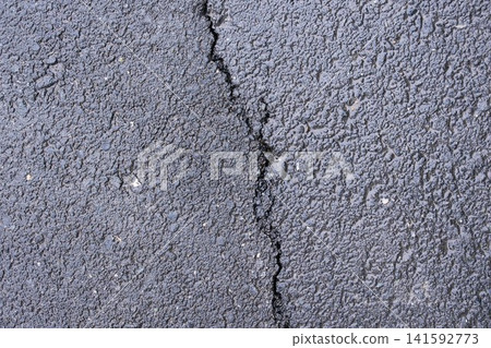 Asphalt texture with a deep crack, close-up top view, industrial background Asphalt texture with a deep crack, close-up top view, industrial background 141592773