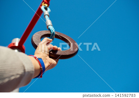 Detailed shot of a hand grasping wooden calisthenics equipment during an outdoor training session Detailed shot of a hand grasping wooden calisthenics equipment during an outdoor training session 141592783