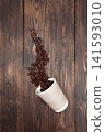 Aromatic roasted coffee beans with take-out mock-up paper cup. dark background, top view, copyspace. 141593010
