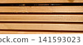 Stacked timber planks creating a textured background, highlighting the natural wood grain and material ready for construction or decorative applications. 141593023