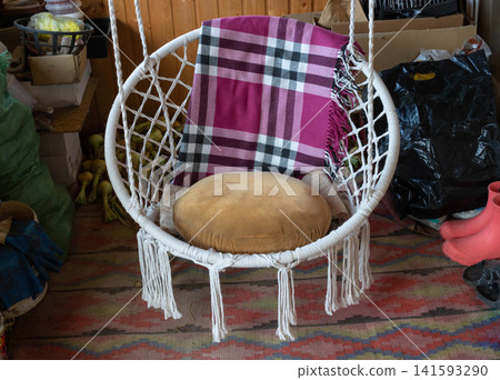 Wicker rocking chair with a brown pillow and blanket. Wicker rocking chair with a brown pillow and blanket. 141593290