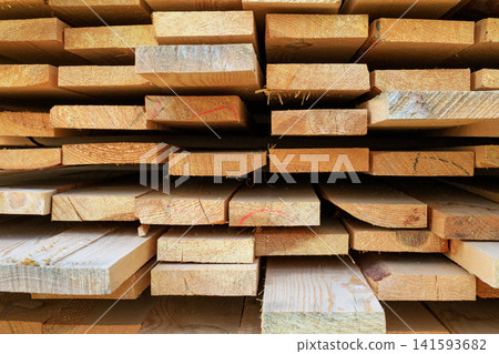 Stacked wooden planks texture. Freshly harvested wooden planks for construction Stacked wooden planks texture. Freshly harvested wooden planks for construction 141593682