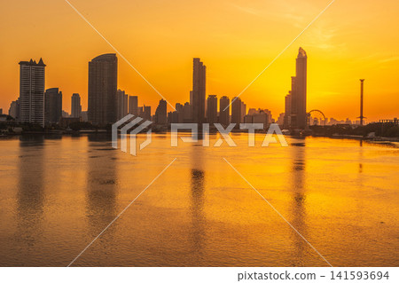 Golden sunset over a sprawling cityscape reflected in a wide river Golden sunset over a sprawling cityscape reflected in a wide river 141593694
