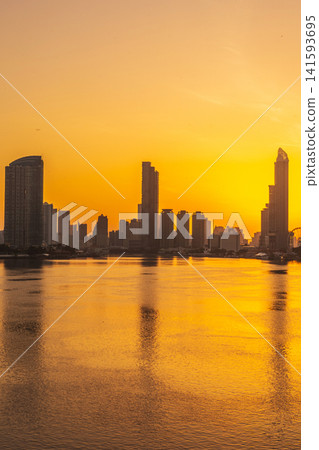 Golden hour cityscape reflecting on the river with modern skyscrapers 141593695