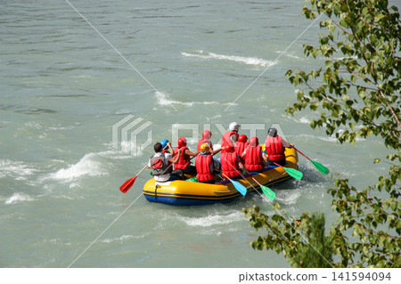 Russia Gorny Altai Katun River 22 June 2025. Group of 10 people rafting in one boat on rapid river. Adventure tourism and extreme water sport in mountain landscape Russia Gorny Altai Katun River 22 June 2025. Group of 10 people rafting in one boat on rapid river. Adventure tourism and extreme water sport in mountain landscape 141594094