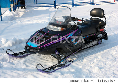 Russia Primorsky Krai Arsenyev 20 January 2026. Snowmobile parked on snow close up view. Winter motor vehicle for snow travel and recreation in Far East mountain landscape Russia Primorsky Krai Arsenyev 20 January 2026. Snowmobile parked on snow close up view. Winter motor vehicle for snow travel and recreation in Far East mountain landscape 141594107