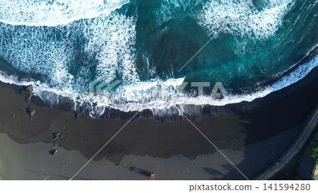 Expansive sea with jagged rocks and foaming surf under cloudy sky. Spectacular drone capture of turquoise waters meeting rugged coastline with wave crashes under windy weather Expansive sea with jagged rocks and foaming surf under cloudy sky. Spectacular drone capture of turquoise waters meeting rugged coastline with wave crashes under windy weather 141594280
