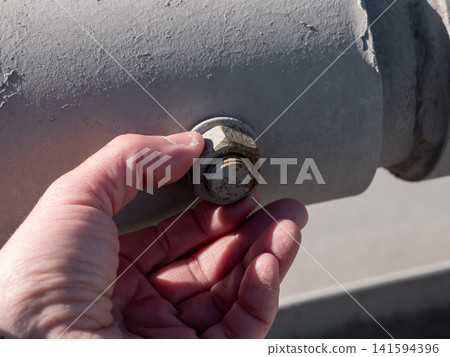 Hand fingers unscrewing large nut close up mechanical repair industrial work concept maintenance and engineering. Hand fingers unscrewing large nut close up mechanical repair industrial work concept maintenance and engineering. 141594396