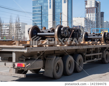 Metal train wheels loaded in truck trailer industrial transport cargo concept. Metal train wheels loaded in truck trailer industrial transport cargo concept. 141594478