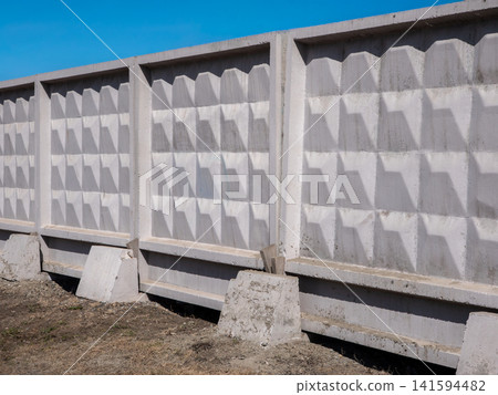 Concrete fence with square pattern against blue sky minimalist architectural design strict geometric forms. Concrete fence with square pattern against blue sky minimalist architectural design strict geometric forms. 141594482