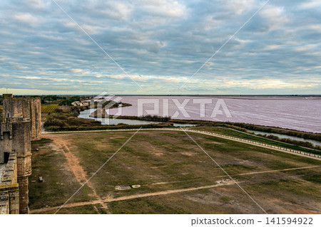 The pink salt lake and the medieval walled Old town of Aigues-Mortes, Camargue, France The pink salt lake and the medieval walled Old town of Aigues-Mortes, Camargue, France 141594922