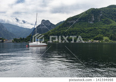 Sailboat on Lake Traunsee in the Salzkammergut, illustrating scenic lake tourism in Austria and classic alpine summer vibe. Sailboat on Lake Traunsee in the Salzkammergut, illustrating scenic lake tourism in Austria and classic alpine summer vibe. 141594998
