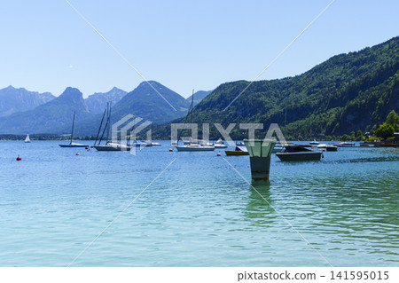 Sailboats on Lake Wolfgangsee in the Salzkammergut, illustrating scenic lake tourism in Austria and classic alpine summer vibe. Sailboats on Lake Wolfgangsee in the Salzkammergut, illustrating scenic lake tourism in Austria and classic alpine summer vibe. 141595015