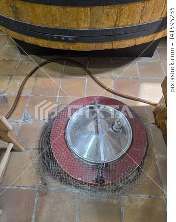 Metal hatch on wooden vat in traditional winery production area during grape processing Metal hatch on wooden vat in traditional winery production area during grape processing 141595235