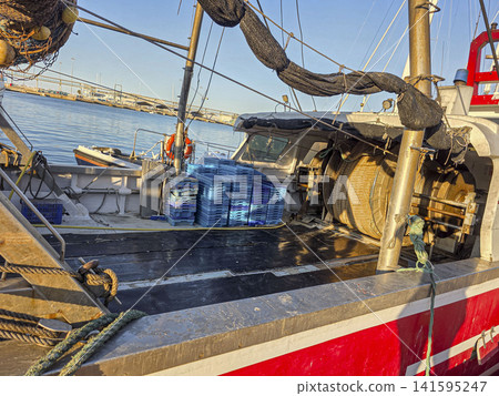 Commercial fishing boat in action during golden hour at the harbor Commercial fishing boat in action during golden hour at the harbor 141595247