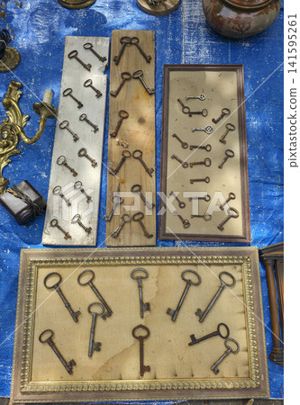 Antique skeleton keys displayed on wooden boards with framed arrangements at an outdoor market Antique skeleton keys displayed on wooden boards with framed arrangements at an outdoor market 141595261
