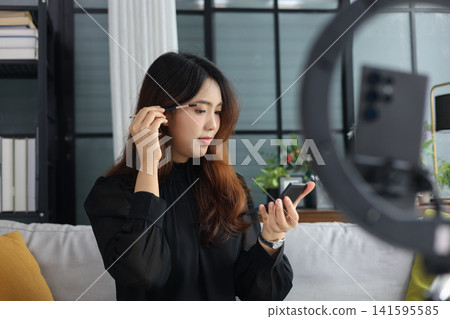 Content creator recording cosmetics review vlog for social media. Content creator recording cosmetics review vlog for social media. 141595585