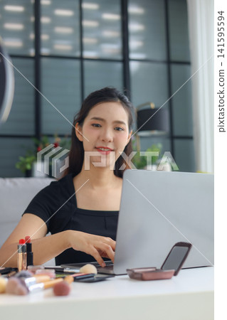 Young woman beauty blogger streaming makeup tutorial with ring light and smartphone. Young woman beauty blogger streaming makeup tutorial with ring light and smartphone. 141595594