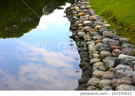 A seawall paved with round stones A seawall paved with round stones 141595612