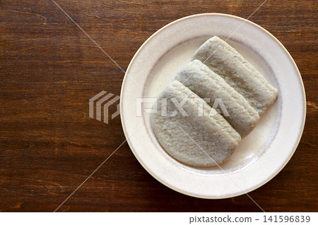 Black fish cake viewed from directly above the table background. Black fish cake viewed from directly above the table background. 141596839