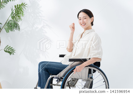 A woman riding a wheelchair A woman riding a wheelchair 141596954