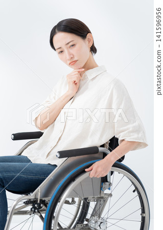 A woman in a wheelchair thinking 141596956