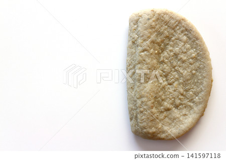 Black fish cake viewed from directly above against a white background. 141597118