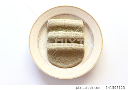 Black fish cake viewed from directly above against a white background. Black fish cake viewed from directly above against a white background. 141597123