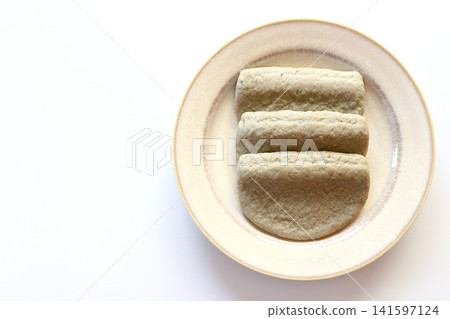 Black fish cake viewed from directly above against a white background. Black fish cake viewed from directly above against a white background. 141597124