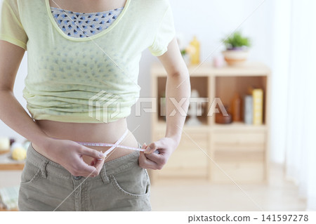 A woman measuring the waist A woman measuring the waist 141597278