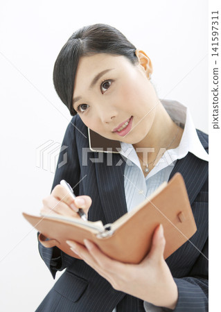 採取筆記的女商人，當打電話時 141597311