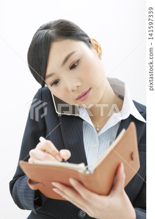 採取筆記的女商人，當打電話時 141597339