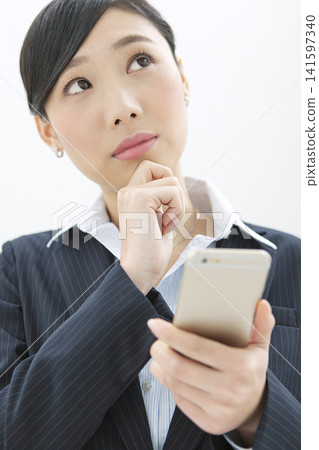 Business woman operating a mobile phone Business woman operating a mobile phone 141597340