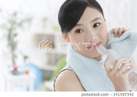 A woman rehydrating during her workout. A woman rehydrating during her workout. 141597342