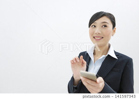 Business woman operating a mobile phone Business woman operating a mobile phone 141597343