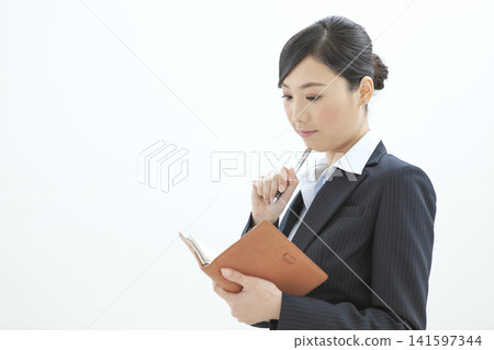 Business woman watching a notebook Business woman watching a notebook 141597344