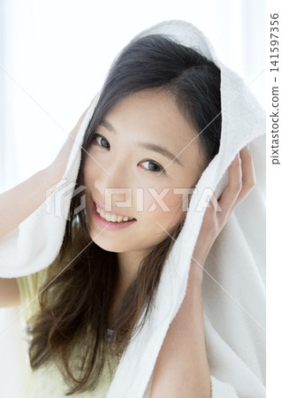用毛巾擦頭髮的女人。 141597356