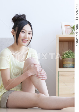 一位女士在客廳為自己做足部按摩。 141597382