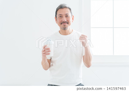 Middle-aged men strike a triumphant pose while holding protein powder. Middle-aged men strike a triumphant pose while holding protein powder. 141597463