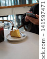 I took a picture of a half-eaten lemon cake with my smartphone. I took a picture of a half-eaten lemon cake with my smartphone. 141597471
