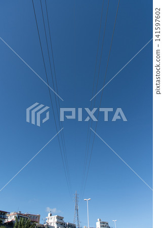 在湛藍的天空下,電線和輸電塔向前向後延伸。 在湛藍的天空下,電線和輸電塔向前向後延伸。 141597602