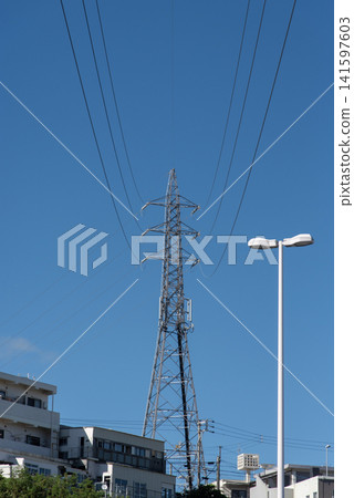 在湛藍的天空下,電線縱橫交錯,城市中可以看到輸電塔。 在湛藍的天空下,電線縱橫交錯,城市中可以看到輸電塔。 141597603