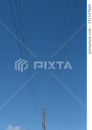 在湛藍的天空下,電線和輸電塔向前向後延伸。 在湛藍的天空下,電線和輸電塔向前向後延伸。 141597604