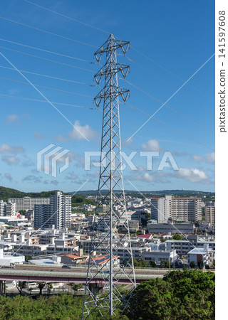Under a clear blue sky, power lines stretch to the left and right, and power transmission towers in the city. Under a clear blue sky, power lines stretch to the left and right, and power transmission towers in the city. 141597608