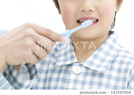 A parent and child in pajamas brushing their teeth. A parent and child in pajamas brushing their teeth. 141597930