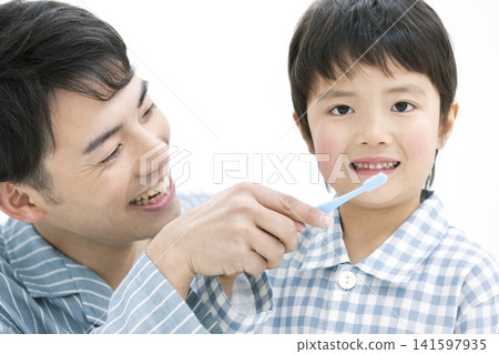 一位家長和孩子穿著睡衣在刷牙。 141597935