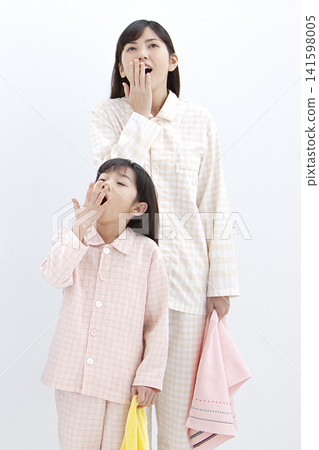 一位家長和孩子穿著睡衣打哈欠。 141598005