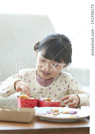 Girl making cookies Girl making cookies 141598173